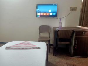 a room with a bed and a tv on the wall at jambu's residence in Karūr