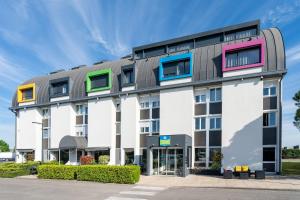 a building with colorful windows on the side of it at Sure Hotel by Best Western Dijon Sud in Chenôve