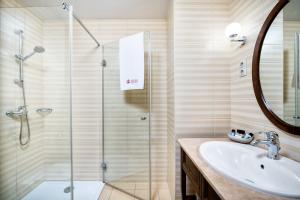 ブダペストにあるミラージュ メディック ホテルのバスルーム(ガラス張りのシャワー、シンク付)