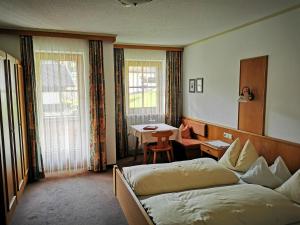 a hotel room with two beds and a table at Balthasarhof, Haus in Finkenberg