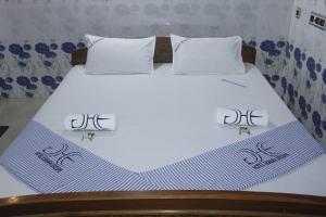 a bed with two white pillows on top of it at Hotel Eswara Temple Stay in Kumbakonam