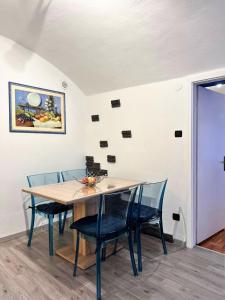 a dining room with a wooden table and blue chairs at Casa Christa in Castello di Fiemme +12 photos