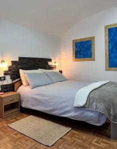 a bedroom with a large white bed and a table at Casa Christa in Castello di Fiemme