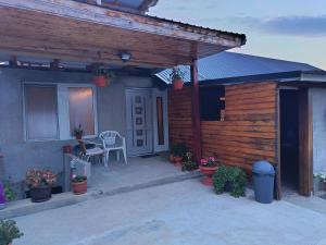 a small house with a patio with a table and chairs at Mini vacanta in Tăşnad