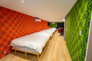 a row of beds in a room with green and red walls at Ciel東池袋 in Tokyo +13 photos