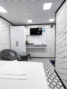 a room with a table and a tv on a wall at Cannaught Stays in New Delhi
