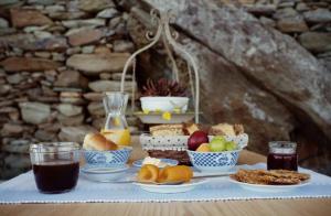 a table topped with plates of food and fruit at Villa Alisachni Andros in Agia Eleousa