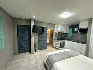 a large bedroom with a bed and a kitchen at Sir Galahad Flatlet 2 in Camelot in Silver Sands