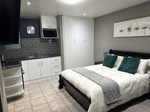 a bedroom with a large bed and a kitchen at Sir Galahad Flatlet 2 in Camelot in Silver Sands
