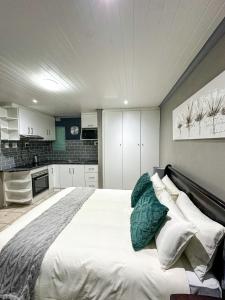 a bedroom with a large white bed with pillows at Sir Galahad Flatlet 2 in Camelot in Silver Sands +11 photos