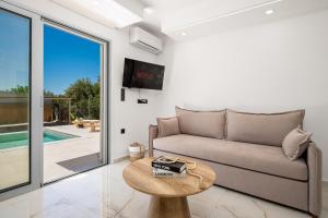 a living room with a couch and a table at Paradise Garden Villa in Moírai