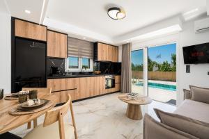 a kitchen and living room with a table and a couch at Paradise Garden Villa in Moírai
