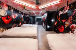a room with four beds and flowers on the walls at Ciel東池袋 in Tokyo