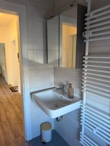 a white bathroom with a sink and a mirror at Apartment Rotenburg in Rotenburg an der Fulda