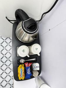 a tea kettle and some food on a table at Cannaught Stays in New Delhi