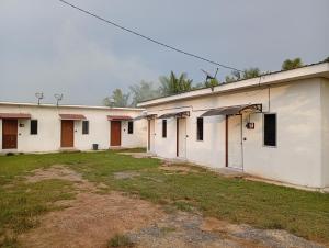 a row of white buildings with a yard at ibilik Changloon in Changlun