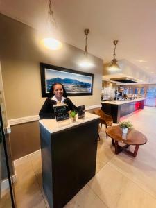 a woman sitting at a counter in a room at Innscape Classic Hotel in Cape Town