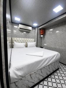 a bedroom with a large white bed in it at Cannaught Stays in New Delhi