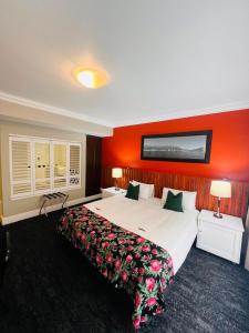 a hotel room with a large bed with red walls at Innscape Classic Hotel in Cape Town