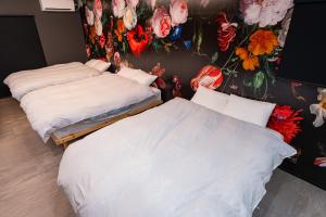 two beds in a room with flowers on the wall at Ciel東池袋 in Tokyo