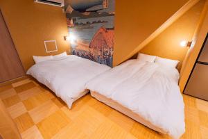 two beds in a room with white sheets at Ciel東池袋 in Tokyo