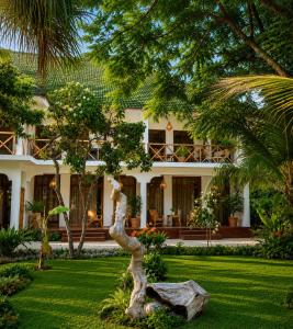 a house with a palm tree in the yard at Tiki Beach Club & Resort in Paje