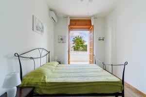 a bedroom with a bed with a green bedspread at Annamaria House by BarbarHouse in Marina di Mancaversa
