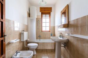 a bathroom with a toilet and a sink and a tub at Annamaria House by BarbarHouse in Marina di Mancaversa +21 photos