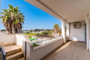a balcony with stairs and a view of the ocean at Annamaria House by BarbarHouse in Marina di Mancaversa