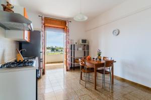 a kitchen and dining room with a table and chairs at Annamaria House by BarbarHouse in Marina di Mancaversa