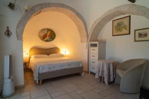 a bedroom with a bed and a chair in a room at I Trulli di Anna in Locorotondo +106 photos