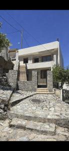 a house with a stone walkway in front of it at Psichro Apartments Zeus in Magoulás