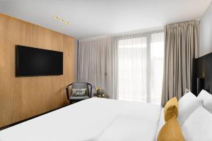 a hotel room with a bed and a television at Hotel Vinifera Wine & Spa 5 Stars Superior in Balatonfüred