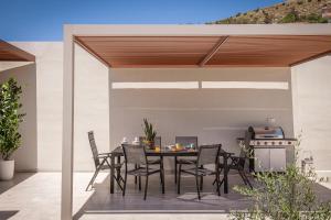 a patio with a table and chairs and a grill at Terra Falconis in Nipidhitós