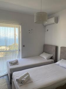 two beds in a room with a window at Sunrise Summit in Egira