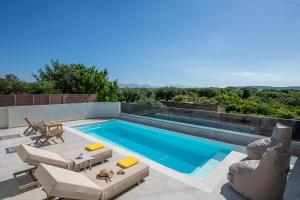 a swimming pool with two lounge chairs and a swimming pool at Terra Falconis in Nipidhitós