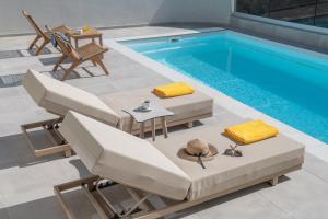 a swimming pool with chairs and a table and a tablektop at Terra Falconis in Nipidhitós