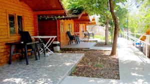 a porch of a house with chairs and a table at TONEDA Seaside Bungalows in Dhërmi