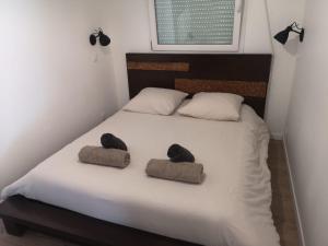 a bedroom with a bed with two hats on it at La Tiny de Jeff in Uzel