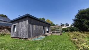 a small wooden building in a field of grass at La Tiny de Jeff in Uzel