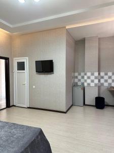 a room with a television on a wall with a kitchen at Ситора in Dushanbe
