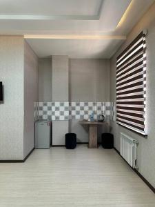 a room with a kitchen with a counter and a table at Ситора in Dushanbe