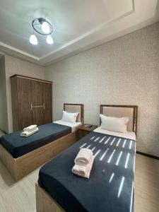 two beds in a hotel room with towels on them at Ситора in Dushanbe