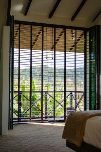 a bedroom with a large window with a view at Padé Langkawi in Ulu Melaka