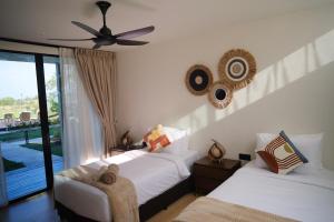 a bedroom with two beds and a ceiling fan at Padé Langkawi in Ulu Melaka
