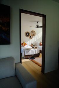 a bedroom with a mirror and a bed and a couch at Padé Langkawi in Ulu Melaka