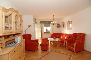 a living room with red couches and a table at Landhaus Almer in Zwiesel