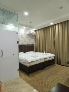 a bedroom with a bed and a glass shower at Alo Grand Hotel in Eshonguzar