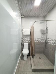a bathroom with a toilet and a shower at Alo Grand Hotel in Eshonguzar