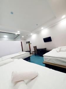 a hotel room with two beds and a mirror at Alo Grand Hotel in Eshonguzar